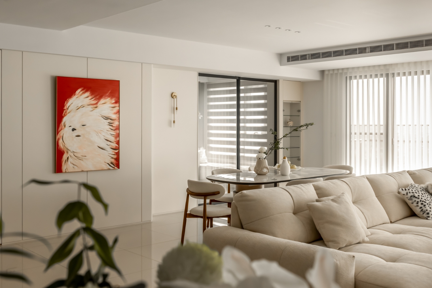 餐廳區白色矽酸鈣板天花板配合壁燈與掛畫，襯托出當代藝術氛圍，透過嚴謹的油漆批土工序與抗裂材料應用，讓板材在通風良好的開放式空間中，依然能保持細膩無裂紋的完美質感與視覺張力