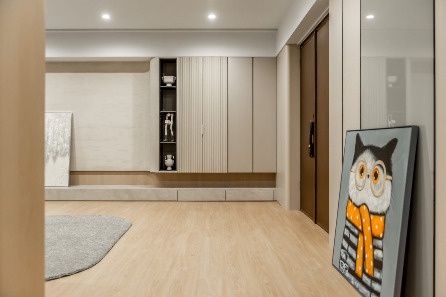 現代簡約風玄關與客廳收納規劃，採用圓弧轉角櫃體與格柵設計，提升空間層次感